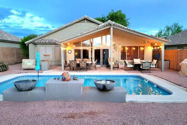 Enjoy the serene backyard and its many amenities: pool, fire pit, BBQ, daybed, and eating area