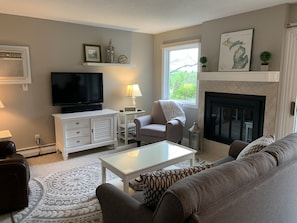 Living room with sound bar, cable tv, dvd/blu ray player, board games and books