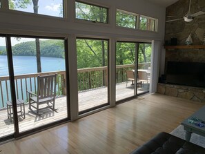 Main living room, with sweeping views of the lake; large fireplace and 65” TV