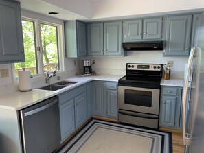 Newly remodeled and well stocked kitchen with quartz countertops.