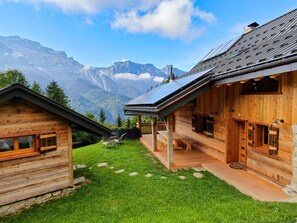 Une grande table et des bancs sous la terrasse pour déjeuner à l'extérieur.