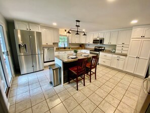 large, fully stocked kitchen with island and two oversize refrigerators/freezers