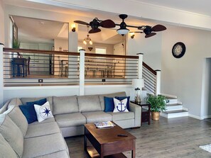 living room with huge sectional, open to the upper-level dining room and kitchen