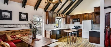 Open kitchen/dining room with high ceilings, deck, TV

