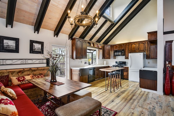 Open kitchen/dining room with high ceilings, deck, TV

