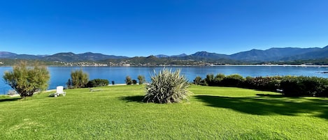 Vue panoramique sur la pelouse, le golfe et les montagnes.