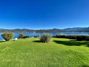 Vue panoramique sur la pelouse, le golfe et les montagnes.