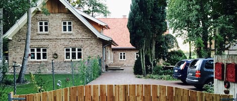 Ansicht Südseite mit großzügigen Parkplätzen und eingezäuntem Gartenbereich