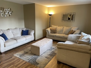 Main level living room with 3 couches. 