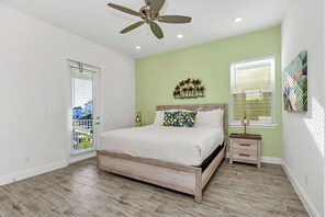 - Calming bedroom of the cottage in Florida - Experience tranquility in adorned with a soothing pastel green accent wall - Embrace serenity and unwind in this peaceful oasis - Cozy retreat with a plush bed, perfect for relaxation