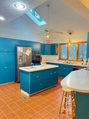 Fully equipped, bright & airy kitchen with island and bar sink.