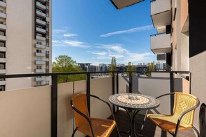 Furnished balcony with green surroundings. 