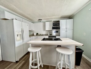 Modem kitchen with dishwasher, stove, kettle, coffee makers and cooking utensils