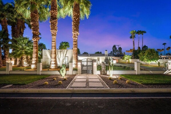 Front of home at night, automatic landscape lighting comes on at dusk