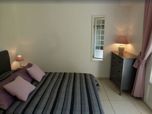 chambre avec lit double et portes vitrées donnant sur la terrasse