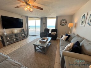 Living room features large Smart HDTV with beautiful coastal decorations.
