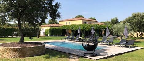 Pool area with deckchairs and parasols. Serenity Rentals Vacation Rentals