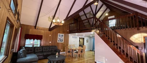 Large living room with tall cathedral ceiling with view of 3rd floor loft.