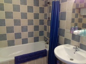 Bathroom with shower over bath, toilet and hand basin