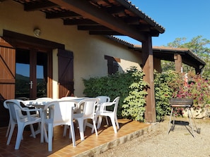 Terrasse couverte avec haie de verdure pour l'intimité. Grande table 8 pers.