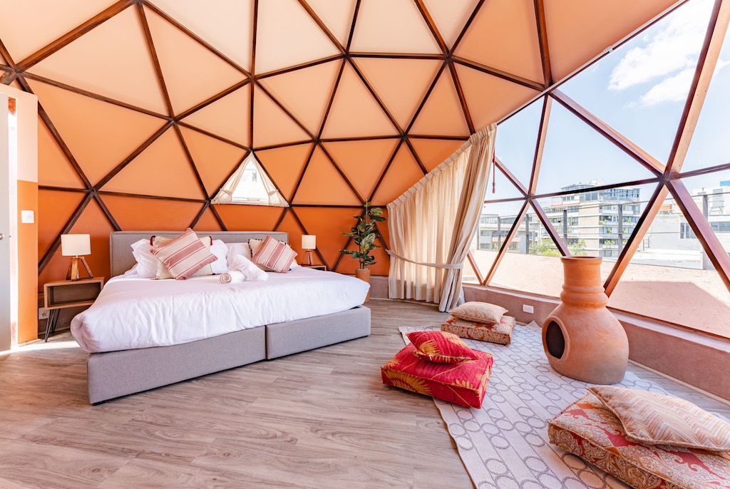 best airbnb mexico city condesa and roma norte | Peach colored geodesic dome apartment rental with bed and seating area