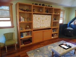 Entertainment/library hutch. A big screen TV is behind the Hawaiian quilt.