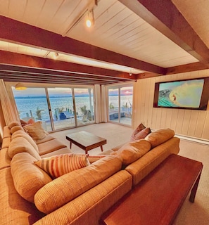 Large spacious living room with giant 72" Smart TV & gorgeous sunset bay views