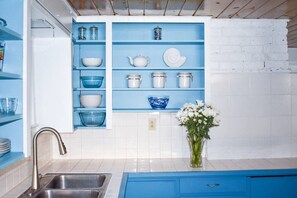 The open upper cabinets in the kitchen have everything you need to create and serve a meal in your home away from home.