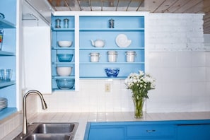The open upper cabinets in the kitchen have everything you need to create and serve a meal in your home away from home.