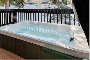 The 6-person private jacuzzi is on the deck right off of the Primary Bedroom