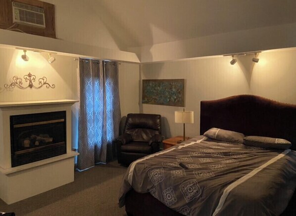 Large master suite with Tv Closet, dresser, comfy chair and work desk 