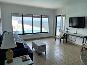 Living area with ocean view and door to the private balcony 