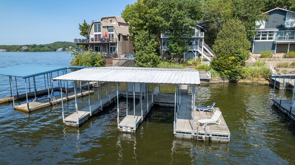 Back of house view of boat dock and decks