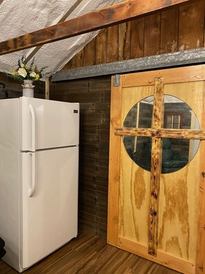 Burnt cross sliding barn door separating bedroom and living space.