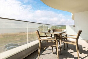 Spacious balcony with outdoor furniture. 