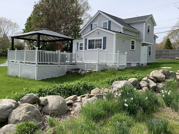 view of house from the extended side yard with the primitive stone wall