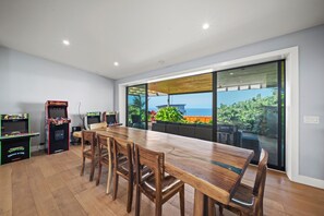 Custom dining area with seating for eight and sweeping coastline views, perfect for group meals with a tropical backdrop.