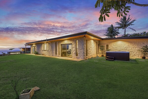 Twilight hues settle over Hale Mahina’s front yard—an ideal spot for sunset reflections surrounded by lava rock privacy.