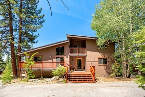 The charming cabin exterior, nestled among towering pines and aspens.