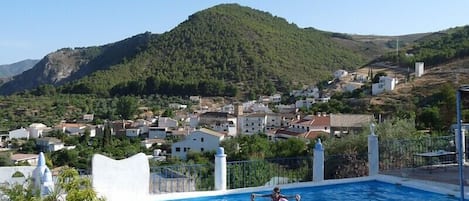 Piscina del Cortijo del Norte y Pueblo de Conchar al fondo.