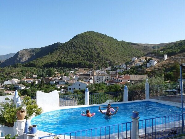 Piscina del Cortijo del Norte y Pueblo de Conchar al fondo.