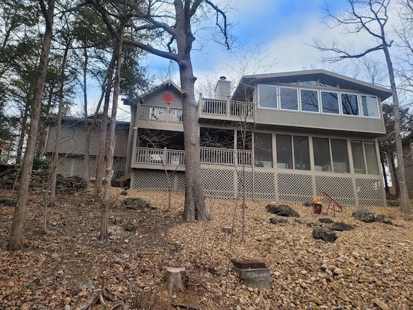 Back view of house with sunroom, screened-in porch, covered deck, and open deck
