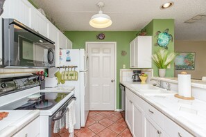 Fully equipped kitchen with coffee maker, toaster, cookware, dinnerware, and other kitchen essentials provided