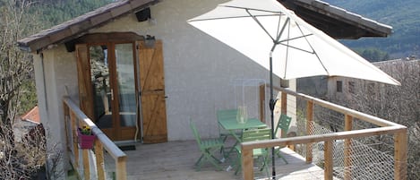 Terrasse spacieuse en bois avec salon de jardin, parasol et 2 chaises longues