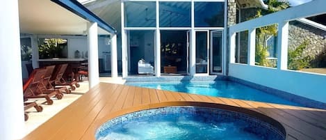 hot tub with pool that is a step down from living area