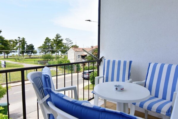 The terrace with garden table and chairs overlook the street and the sea.