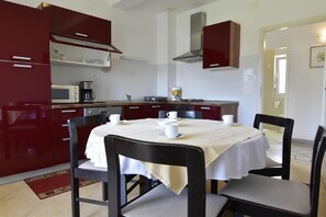 The equipped kitchen and the dining area with table and chairs
