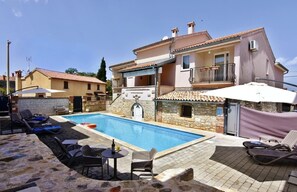 Der Poolbereich mit Liegestühlen und Sonnenschirmen verfügbar