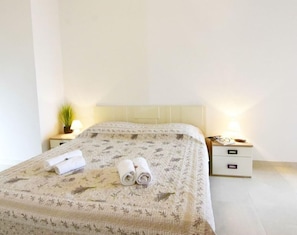 La chambre avec lit double 2 tables de chevet avec lampes de chevet