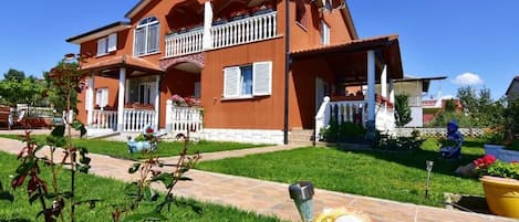 L'extérieur de la maison, le jardin bien entretenu et clôturé.